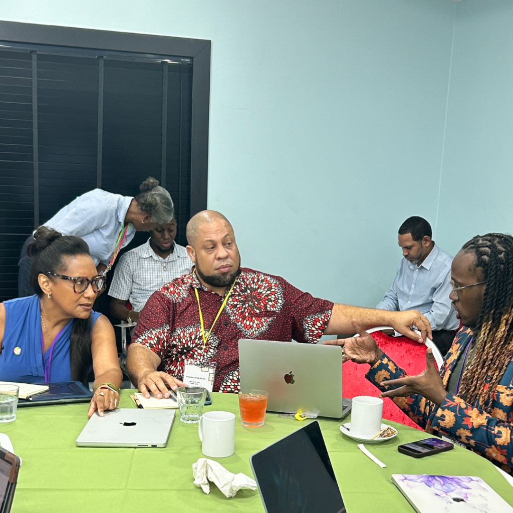 ILGA-NAC regional program manager, Sharon Mottley, sitting at a table with Dane Lewis and Glenroy Murray discussing issues at the Transcendence Human Rights Conference